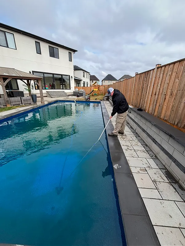 Technician using a squeegee to smooth a new pool liner during installation