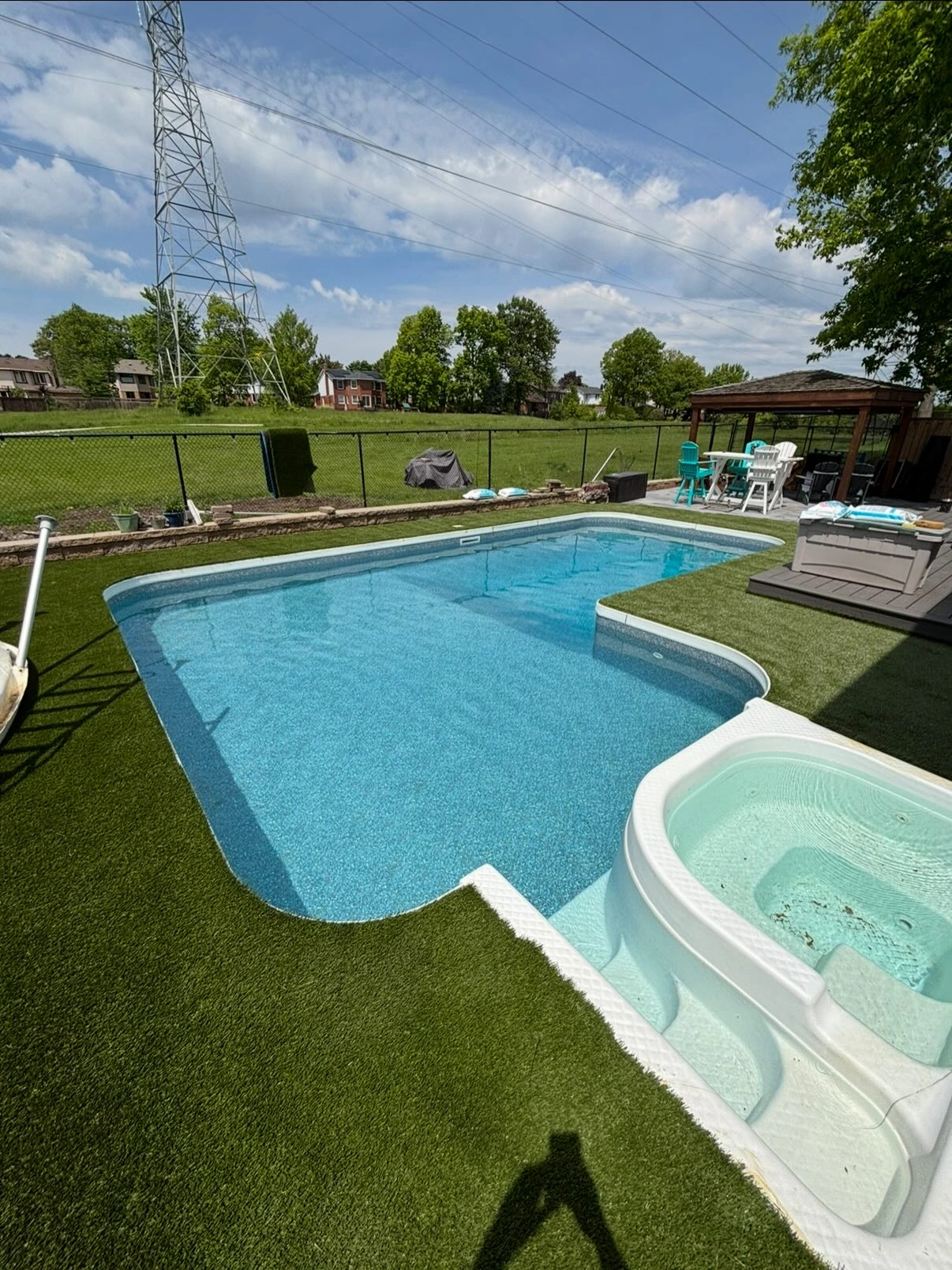 Newly installed pool with hot tub and artificial grass in a backyard